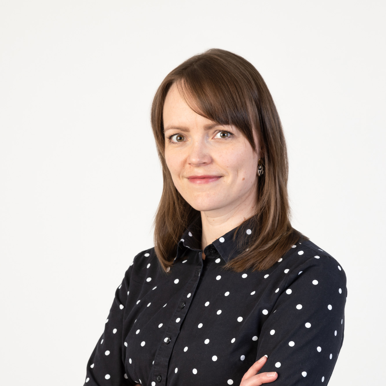 Heidi Enbacka vaalean taustan edessä.